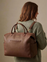 Wyld Bub diaper bag worn as a backpack using the convertible strap and gold D-rings