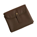 The Everyday Change Mat folded, chocolate pebbled vegan leather with gold snap