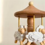 Close up detail of the white wooden sheep and gold rods on the Wyld Bub heirloom carousel
