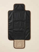 The Everyday Change Mat unfolded showing the wipe-clean black change surface and storage pocket