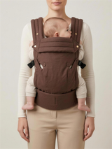 Mother wearing the Cocoa Linen baby carrier, front view studio shot
