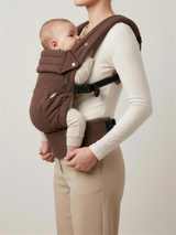 Side profile of mother wearing the Cocoa Linen baby carrier showing ergonomic seated position