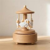 Wyld Bub heirloom wooden musical carousel with four white sheep, natural beech wood, on a nursery dresser