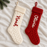 Ivory and red personalised cable-knit Christmas stockings with Noah and Olivia names on linen